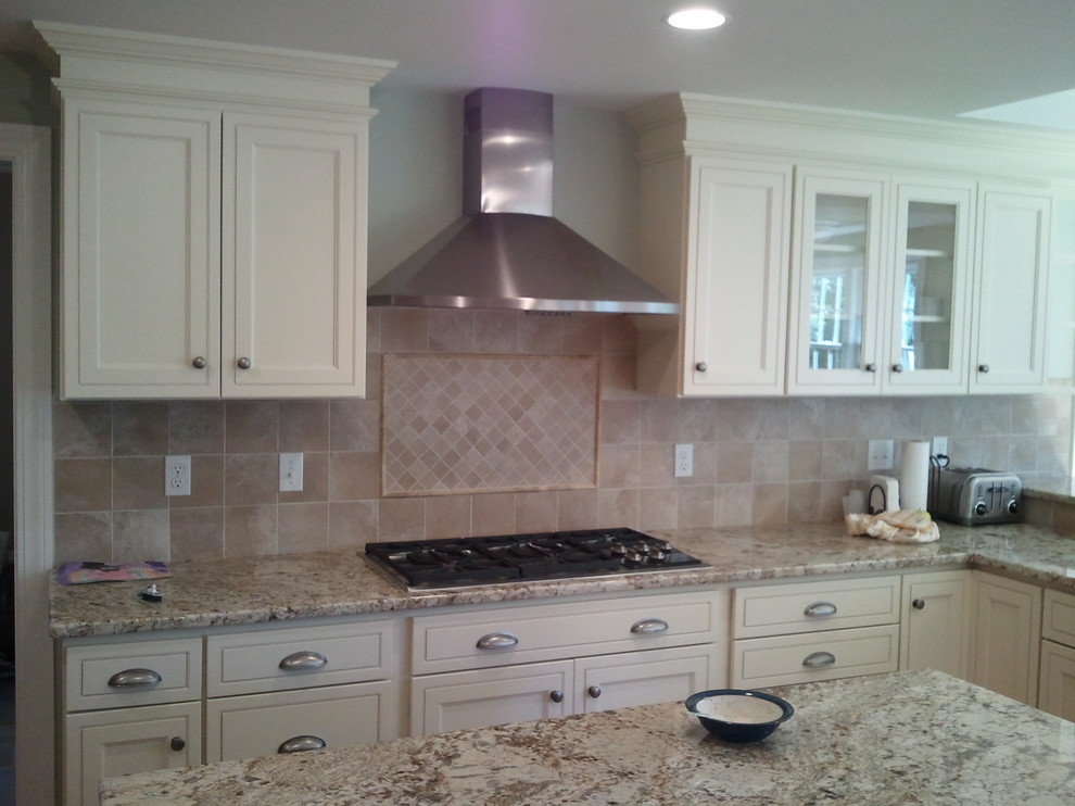 Eat-in kitchen - transitional u-shaped light wood floor eat-in kitchen idea in Boston with an undermount sink, shaker cabinets, white cabinets, quartz countertops, beige backsplash, stainless steel appliances and an island