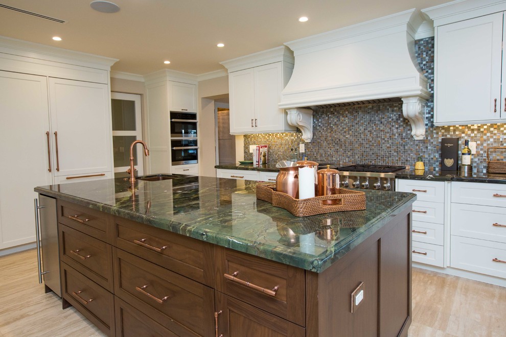 Example of a large transitional u-shaped light wood floor open concept kitchen design in Miami with a farmhouse sink, shaker cabinets, stainless steel appliances, an island, white cabinets, granite countertops, metallic backsplash and mosaic tile backsplash