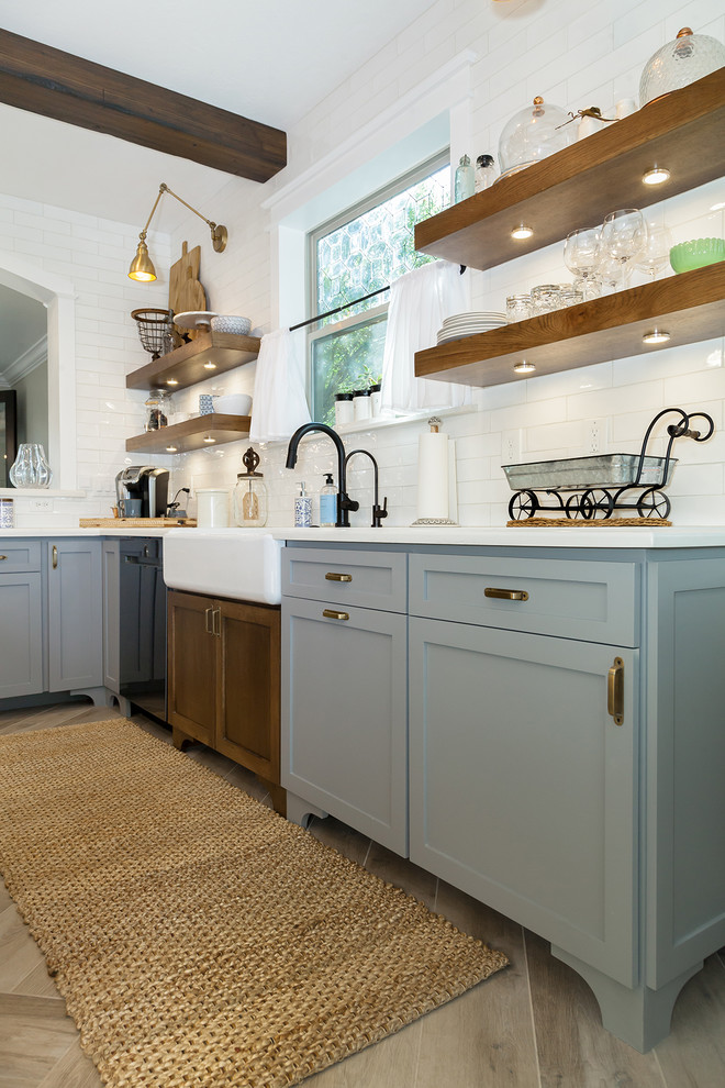 Large transitional l-shaped porcelain tile and brown floor eat-in kitchen photo in Phoenix with a farmhouse sink, shaker cabinets, gray cabinets, quartz countertops, white backsplash, glass sheet backsplash, stainless steel appliances, an island and white countertops