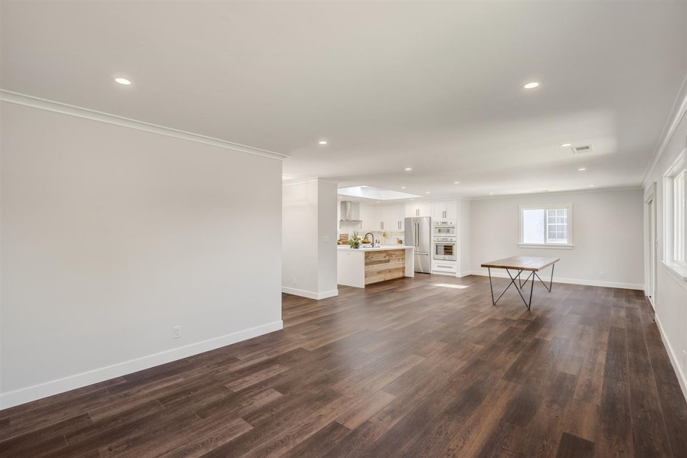 Photo of a medium sized contemporary open plan living room in San Francisco with white walls, vinyl flooring, no tv and brown floors.