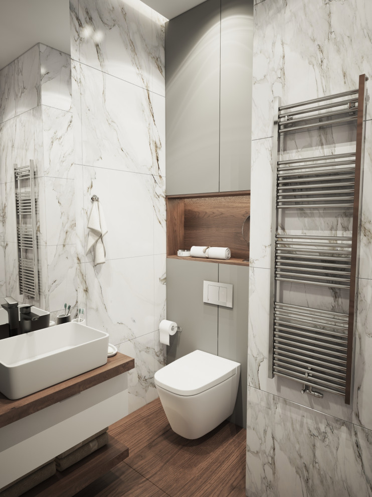 Foto på ett litet funkis en-suite badrum, med luckor med glaspanel, en hörndusch, en vägghängd toalettstol, marmorkakel, grå väggar, målat trägolv och dusch med skjutdörr