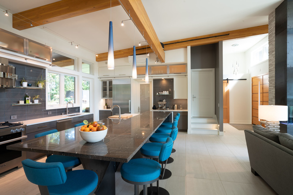 Photo of a contemporary l-shaped open plan kitchen in Seattle with an undermount sink, flat-panel cabinets, granite benchtops, blue splashback, porcelain splashback, stainless steel appliances, porcelain floors, with island, white floor and multi-coloured benchtop.