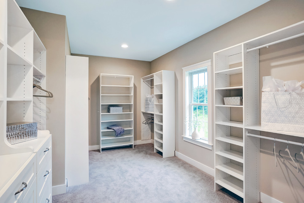 Photo of a large country gender-neutral walk-in wardrobe in Other with open cabinets, carpet and white cabinets.