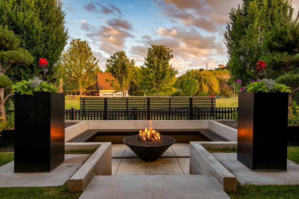 Photo of a large modern backyard patio in Boise with an outdoor kitchen, concrete slab and a roof extension.