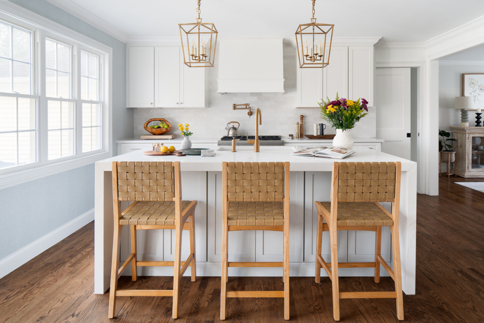Inspiration for a mid-sized transitional eat-in kitchen in New York with an undermount sink, shaker cabinets, white cabinets, quartz benchtops, white splashback, ceramic splashback, stainless steel appliances, dark hardwood floors, with island, brown floor and white benchtop.