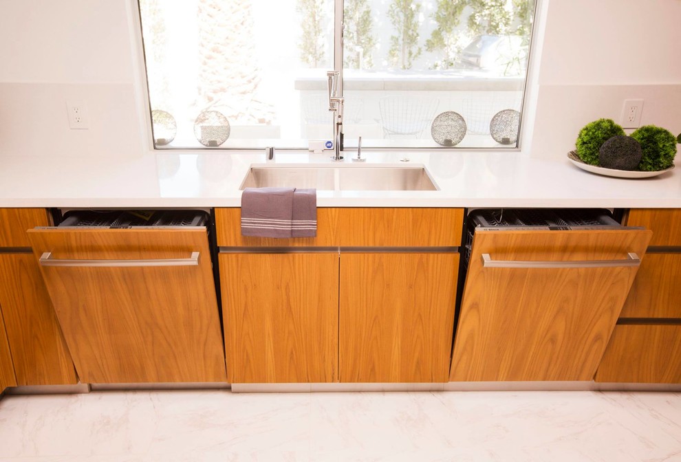 This is an example of a mid-sized modern eat-in kitchen in Houston with an undermount sink, flat-panel cabinets, medium wood cabinets, quartz benchtops, white splashback, glass sheet splashback, panelled appliances and marble floors.