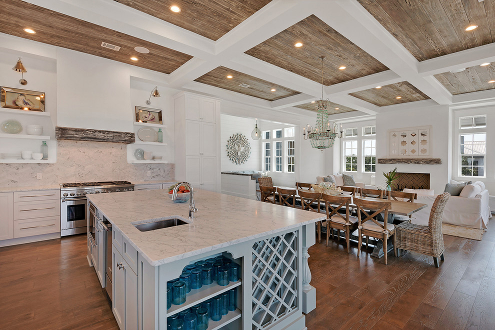 Inspiration for an expansive beach style l-shaped open plan kitchen in Miami with a double-bowl sink, recessed-panel cabinets, white cabinets, marble benchtops, white splashback, marble splashback, stainless steel appliances, dark hardwood floors, with island and beige floor.