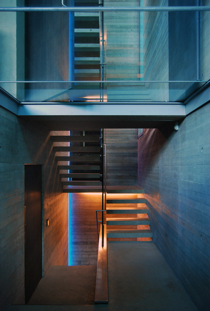 Photo of a mid-sized contemporary concrete u-shaped staircase in London with open risers.