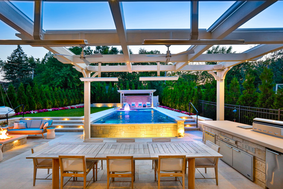 Ispirazione per una piscina monocorsia tradizionale rettangolare di medie dimensioni e dietro casa con paesaggistica bordo piscina e pavimentazioni in pietra naturale
