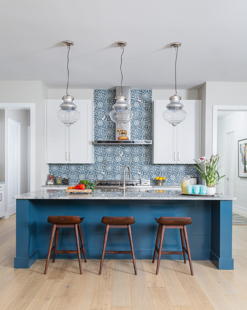 This is an example of a mid-sized transitional kitchen in Austin with shaker cabinets, white cabinets, marble benchtops, cement tile splashback, stainless steel appliances, light hardwood floors, with island and multi-coloured splashback.