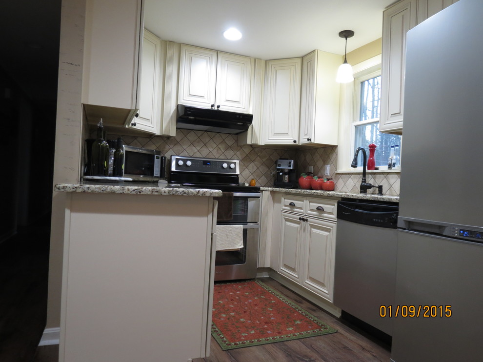 Inspiration for a mid-sized u-shaped eat-in kitchen remodel in DC Metro with a double-bowl sink, raised-panel cabinets, white cabinets, granite countertops, beige backsplash, porcelain backsplash and stainless steel appliances