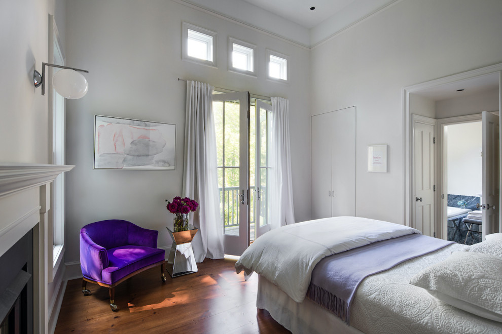 На фото: хозяйская спальня среднего размера в стиле кантри с белыми стенами, паркетным полом среднего тона, стандартным камином, фасадом камина из дерева, коричневым полом и сводчатым потолком
