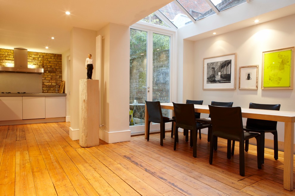 Ispirazione per una grande sala da pranzo aperta verso la cucina minimal con pavimento in legno massello medio