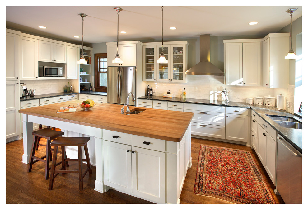 Photo of a large arts and crafts l-shaped eat-in kitchen in Minneapolis with an undermount sink, shaker cabinets, white cabinets, granite benchtops, white splashback, subway tile splashback, stainless steel appliances, dark hardwood floors and with island.