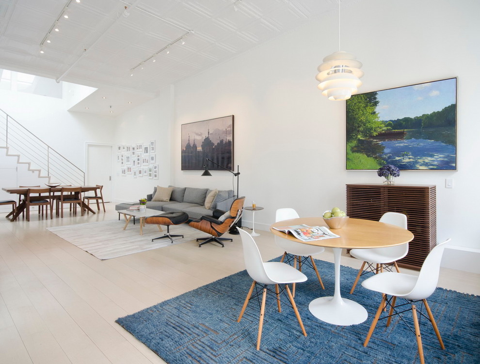 Inspiration for a large scandinavian open concept living room in New York with white walls and light hardwood floors.