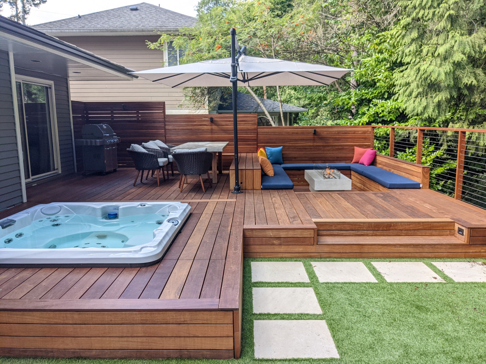 Diseño de terraza minimalista de tamaño medio en patio trasero con barandilla de cable