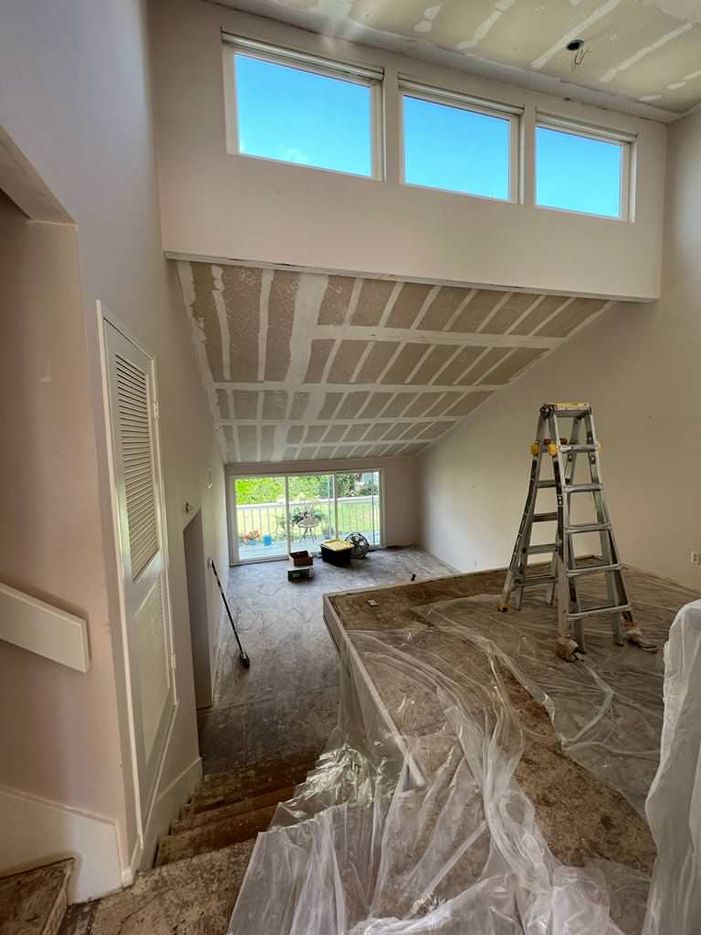 Popcorn ceiling removed, floor removed, kitchen demolished.