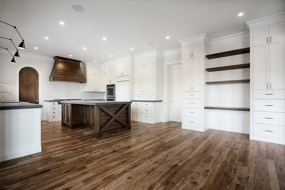 Large transitional u-shaped eat-in kitchen photo in Calgary with shaker cabinets, paneled appliances and an island