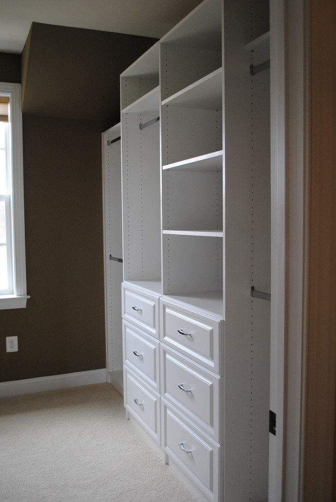 Inspiration for a mid-sized traditional walk-in wardrobe in DC Metro with raised-panel cabinets, white cabinets and carpet.