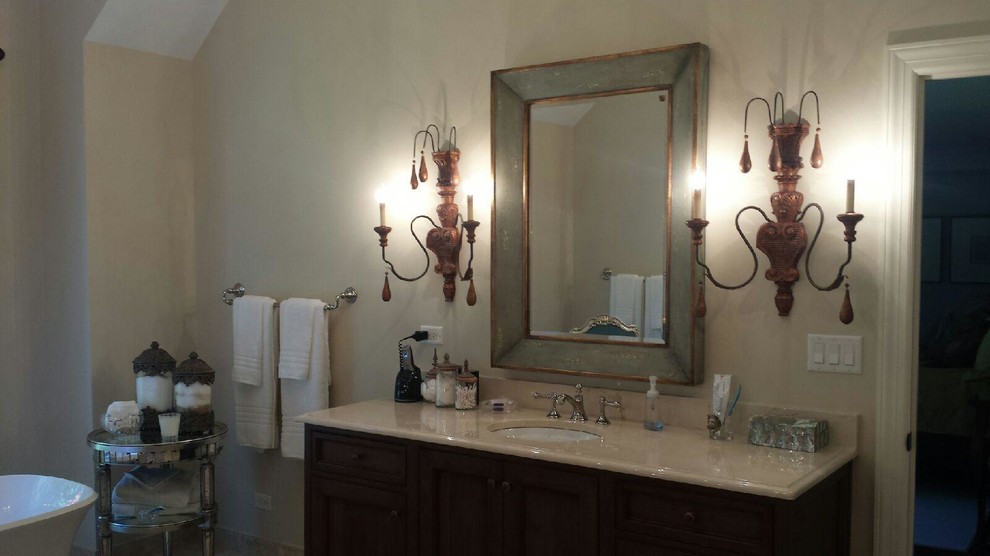 Example of a transitional master travertine floor freestanding bathtub design in Chicago with recessed-panel cabinets, dark wood cabinets, an undermount sink, beige walls and marble countertops