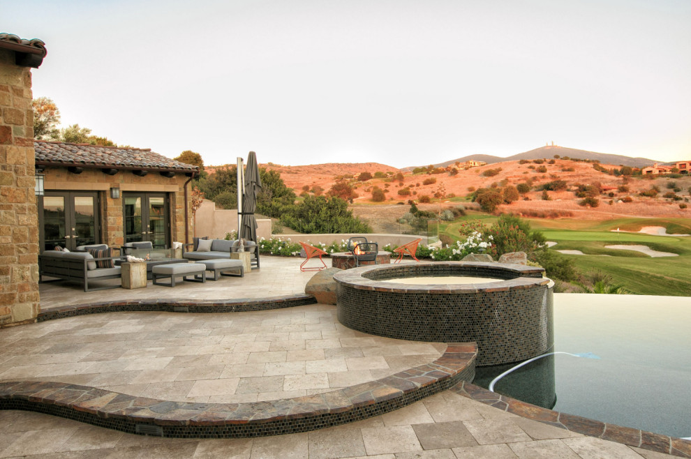 Inspiration for a large mediterranean backyard full sun xeriscape in San Diego with a fire feature and natural stone pavers.
