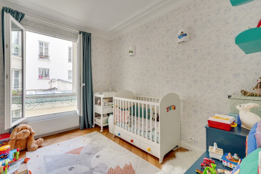 Design ideas for a small contemporary nursery for boys in Paris with multi-coloured walls, medium hardwood floors, brown floor and wallpaper.