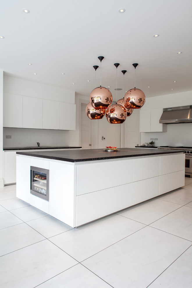 Inspiration for an expansive modern kitchen in London with flat-panel cabinets, white cabinets, stainless steel appliances and with island.