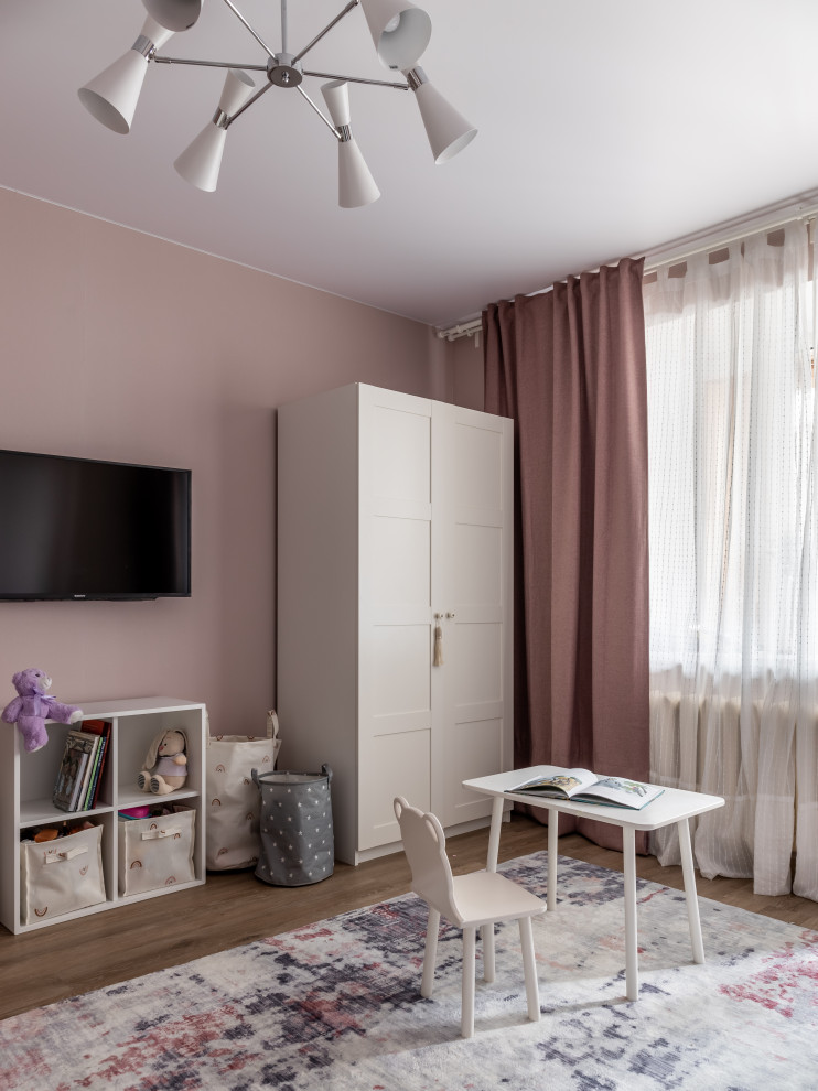 Cette photo montre une chambre d'enfant de 4 à 10 ans tendance de taille moyenne avec un mur rose, un sol en vinyl, un sol marron et du papier peint.