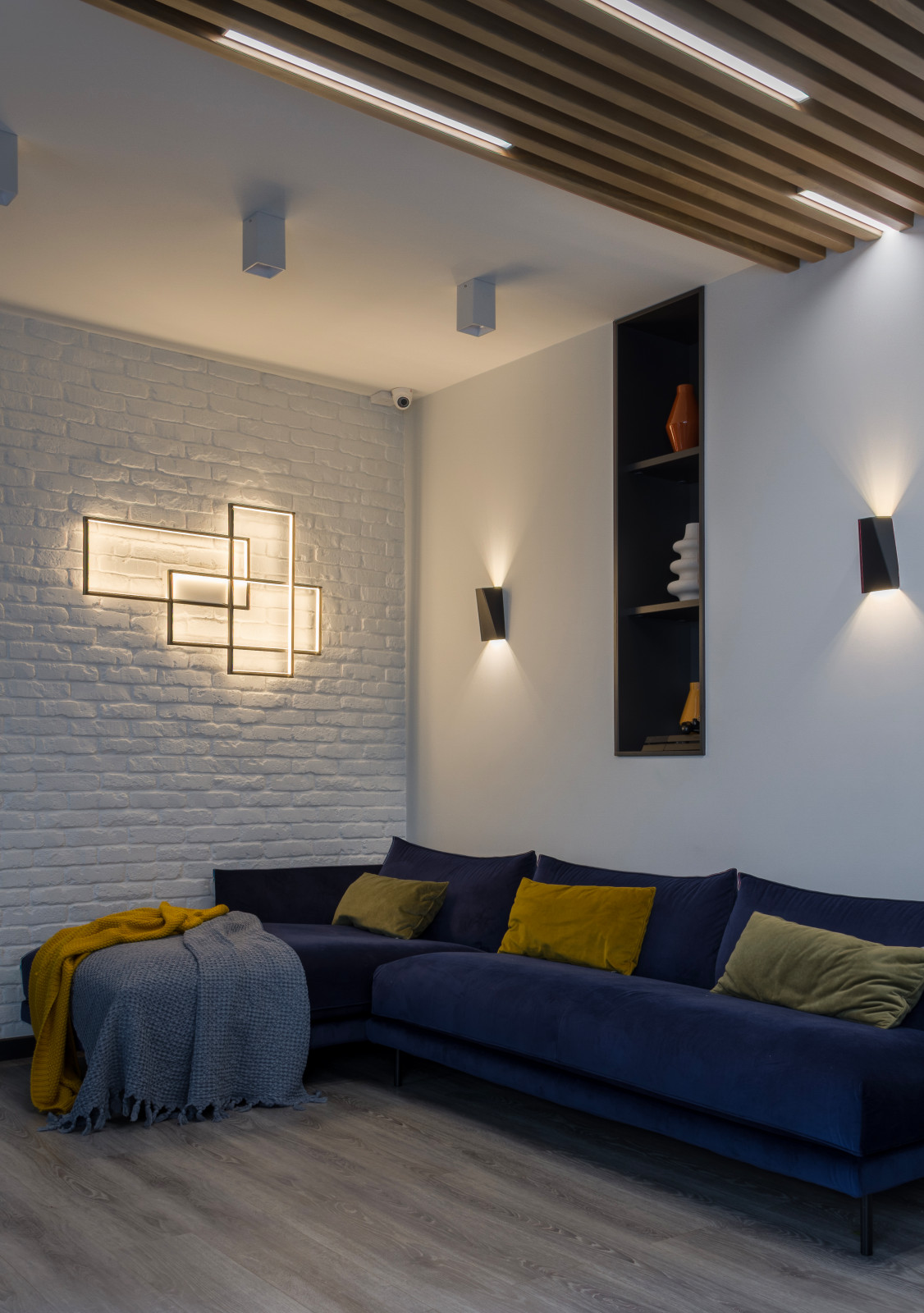 Гостиная с синим диваном при вечернем освещении