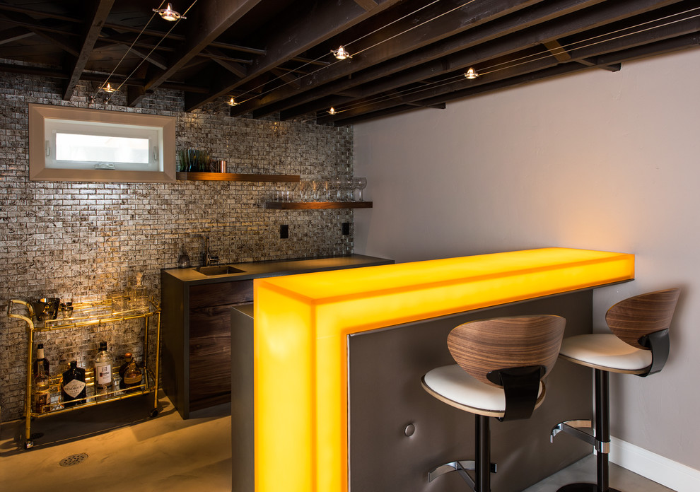 This is an example of a mid-sized contemporary seated home bar in Other with grey splashback, concrete floors, an undermount sink, flat-panel cabinets, dark wood cabinets, glass benchtops, mosaic tile splashback and yellow benchtop.