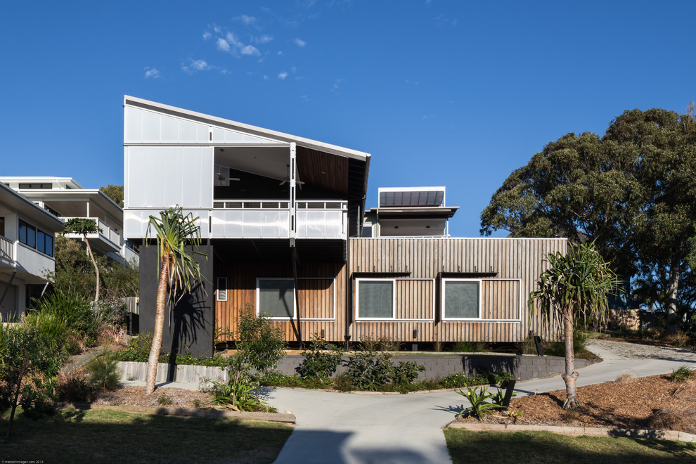 This is an example of a mid-sized contemporary two-storey exterior in Brisbane with mixed siding and a shed roof.