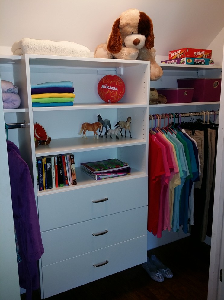 This is an example of a mid-sized modern women's built-in wardrobe in Other with flat-panel cabinets, white cabinets and dark hardwood floors.