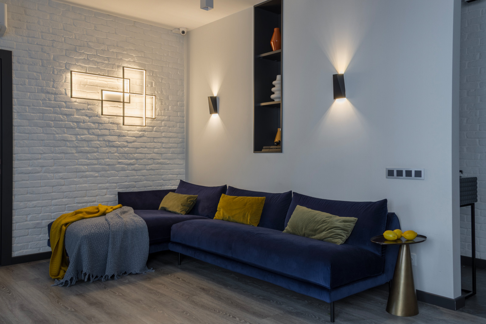 Гостиная с синим диваном при вечернем освещении