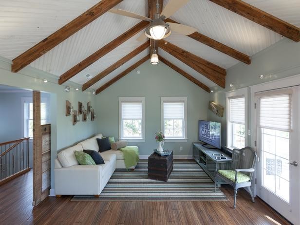 Design ideas for a mid-sized eclectic loft-style family room in Atlanta with a library, blue walls, medium hardwood floors and a freestanding tv.