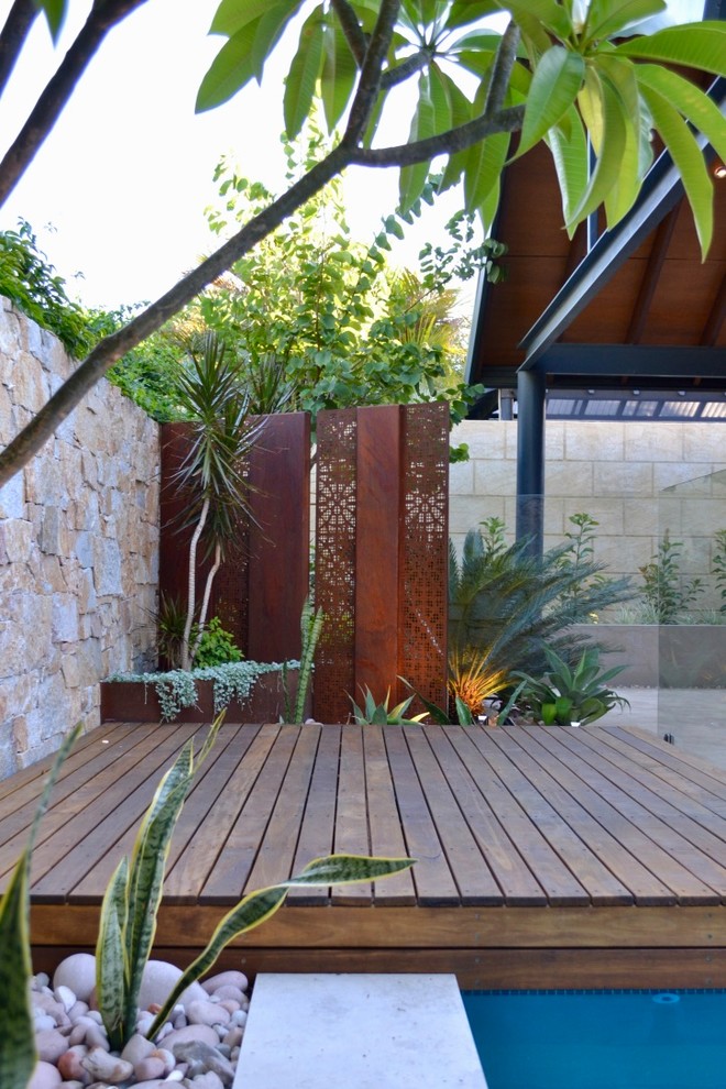 Inspiration for a small contemporary backyard partial sun xeriscape for summer in Perth with with rock feature and decking.