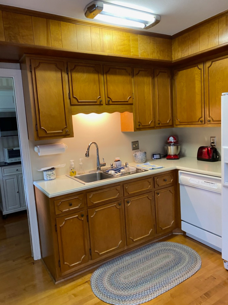 Photo of a small classic u-shaped kitchen in DC Metro with a double-bowl sink, recessed-panel cabinets, granite worktops, stainless steel appliances, medium hardwood flooring and no island.