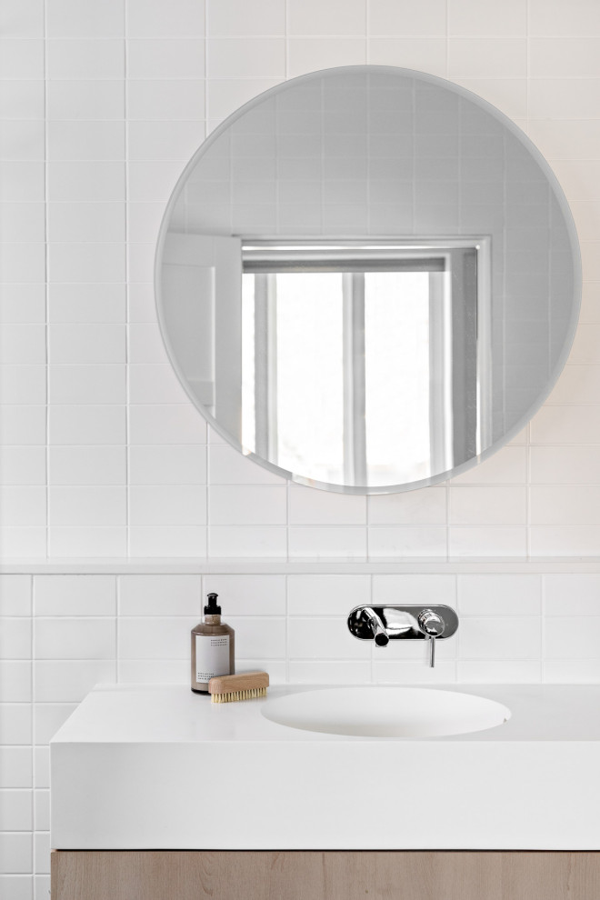 Источник вдохновения для домашнего уюта: ванная комната среднего размера в стиле модернизм с плоскими фасадами, светлыми деревянными фасадами, открытым душем, унитазом-моноблоком, белой плиткой, керамической плиткой, белыми стенами, бетонным полом, монолитной раковиной, столешницей из искусственного камня, зеленым полом, открытым душем, белой столешницей, тумбой под две раковины и подвесной тумбой