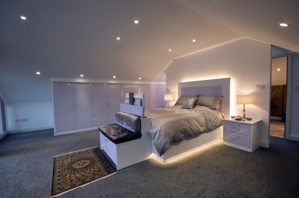 Large contemporary master bedroom in Manchester with carpet.