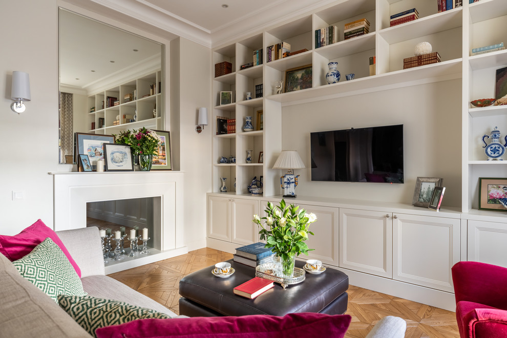 This is an example of a mid-sized traditional open concept living room in Moscow with a library, beige walls, medium hardwood floors, a standard fireplace, a wood fireplace surround, a freestanding tv and yellow floor.