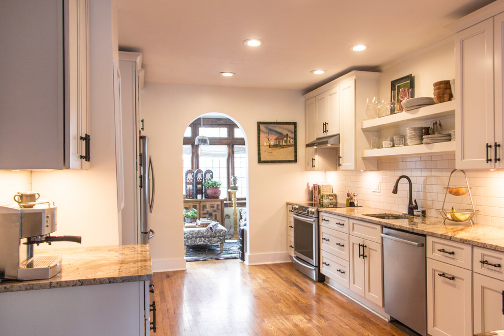 Inspiration for a transitional medium tone wood floor kitchen remodel with granite countertops, subway tile backsplash and stainless steel appliances