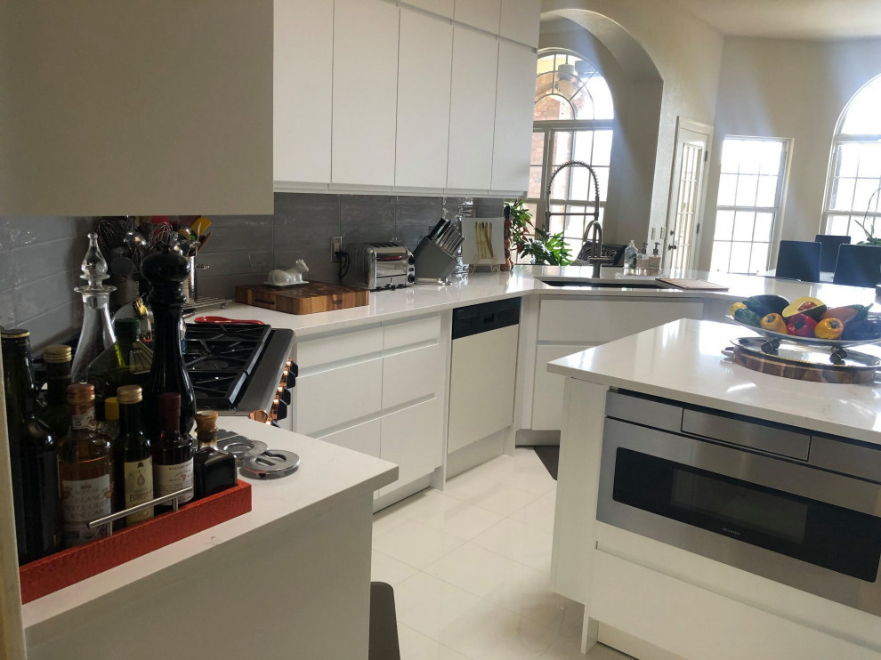 Photo of a mid-sized modern u-shaped eat-in kitchen in Austin with an undermount sink, flat-panel cabinets, grey cabinets, quartz benchtops, grey splashback, ceramic splashback, stainless steel appliances, with island and white benchtop.