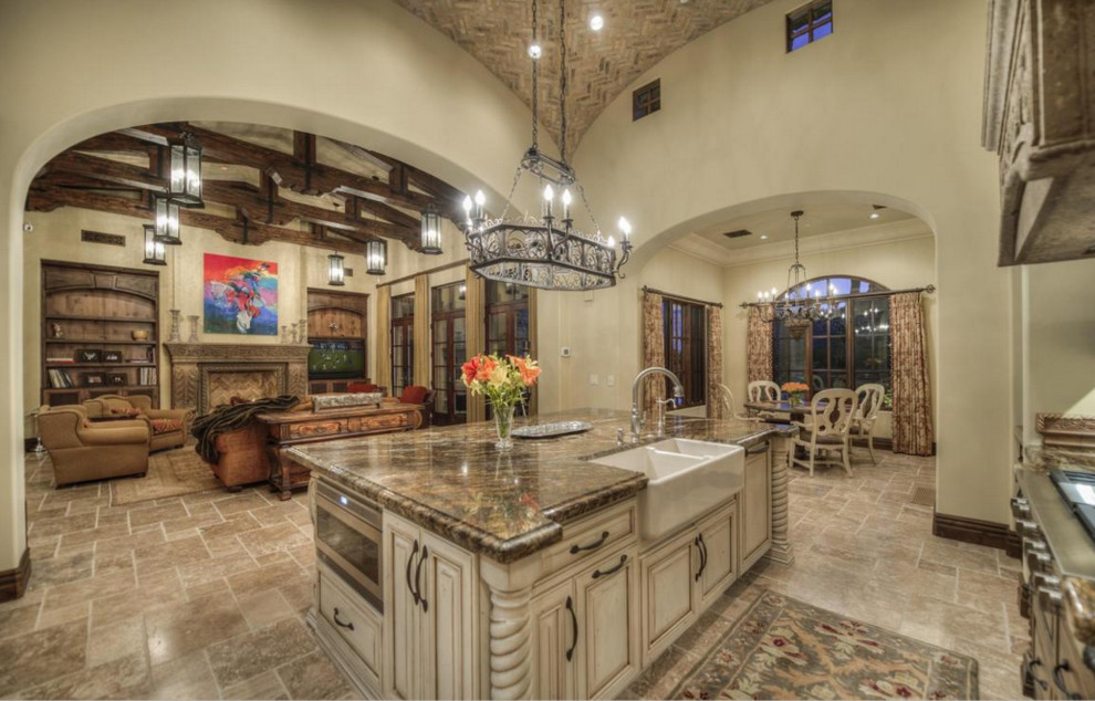 Huge galley travertine floor open concept kitchen photo in Phoenix with a farmhouse sink, raised-panel cabinets, medium tone wood cabinets, granite countertops, beige backsplash, mosaic tile backsplash, stainless steel appliances and an island