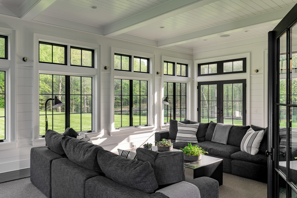 Photo of a large country sunroom in New York with a standard ceiling, grey floor and dark hardwood floors.