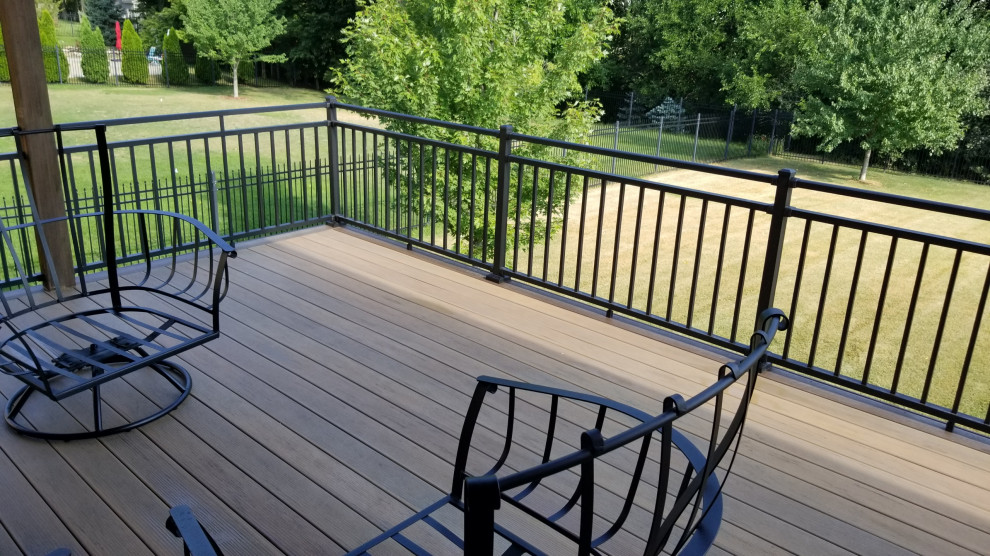 Mid-sized backyard second story privacy and metal railing deck photo in Other with a roof extension