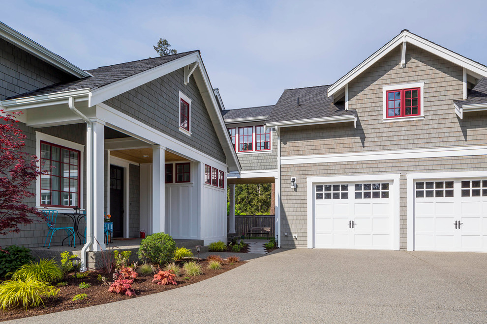 Large beach style two-storey grey house exterior in Seattle with wood siding, a gable roof and a shingle roof.