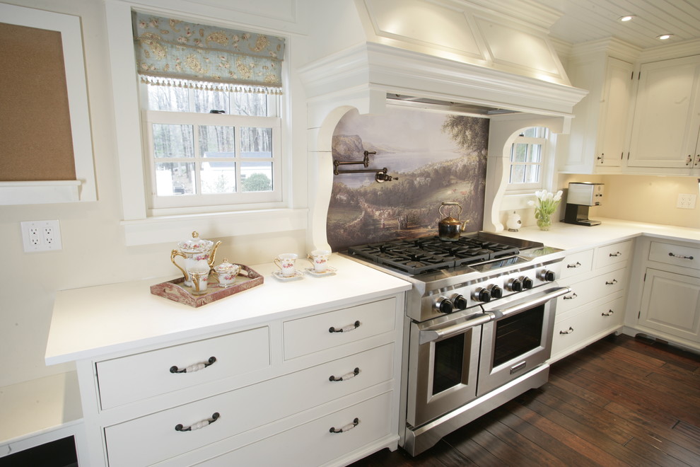 Inspiration for a mid-sized country l-shaped open plan kitchen in New York with a farmhouse sink, raised-panel cabinets, white cabinets, solid surface benchtops, stainless steel appliances, dark hardwood floors and with island.