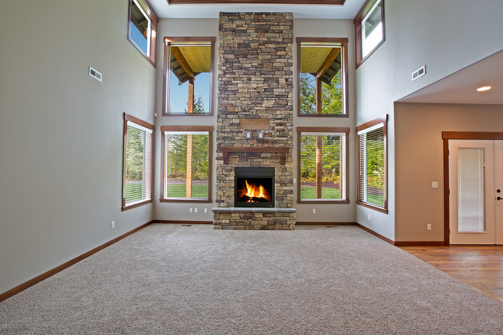 Large arts and crafts family room in Seattle with beige walls, carpet, a standard fireplace, a stone fireplace surround and a wall-mounted tv.