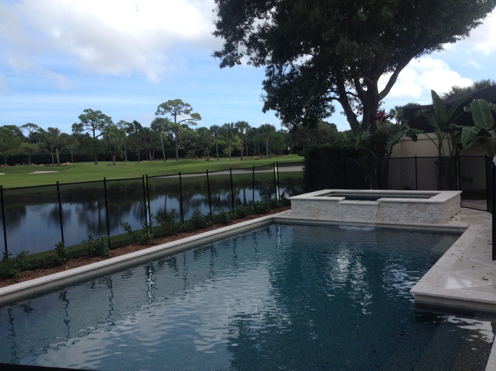 Trendy backyard custom-shaped pool fountain photo in Miami with decking