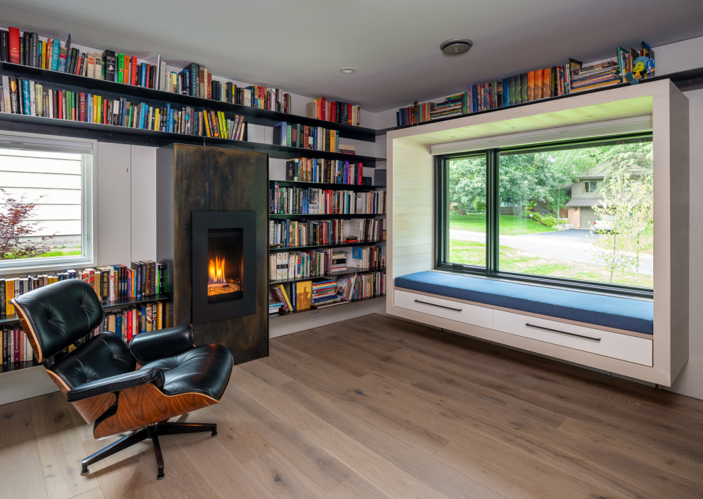 Mid-sized midcentury open concept living room in Minneapolis with a library, white walls, a standard fireplace and a metal fireplace surround.