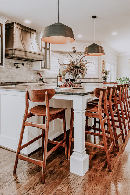 Eat-in kitchen - mid-sized transitional medium tone wood floor and brown floor eat-in kitchen idea with a farmhouse sink, shaker cabinets, white cabinets, soapstone countertops, gray backsplash, porcelain backsplash, stainless steel appliances, an island and black countertops